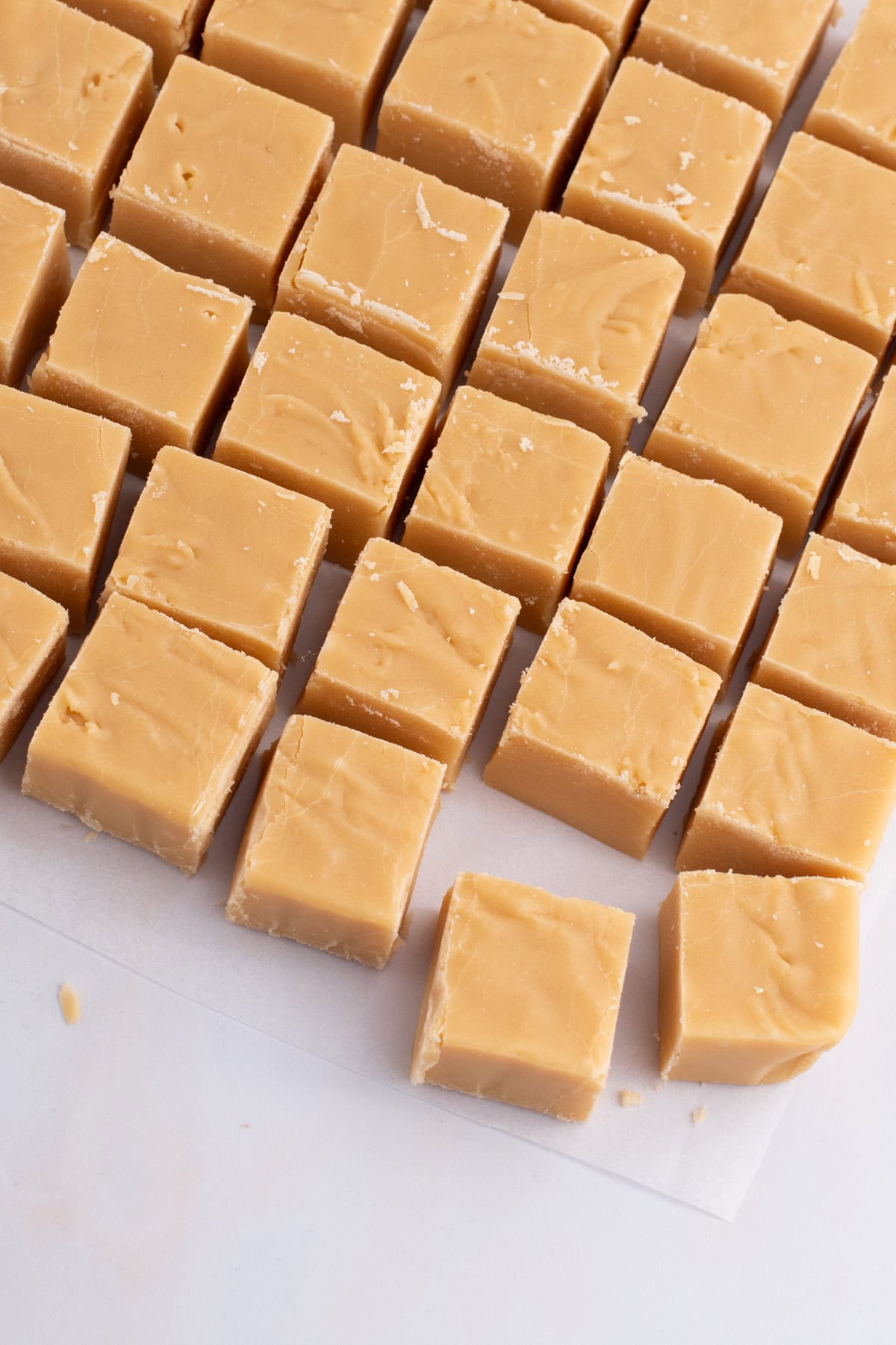 Rows of homemade Scottish tablet squares laid out on baking paper, from a traditional Scottish recipe.