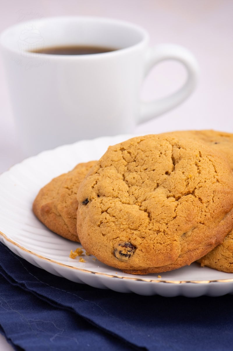 Plate of freshly baked Coffee Buns with golden crust, next to a cup of black coffee.