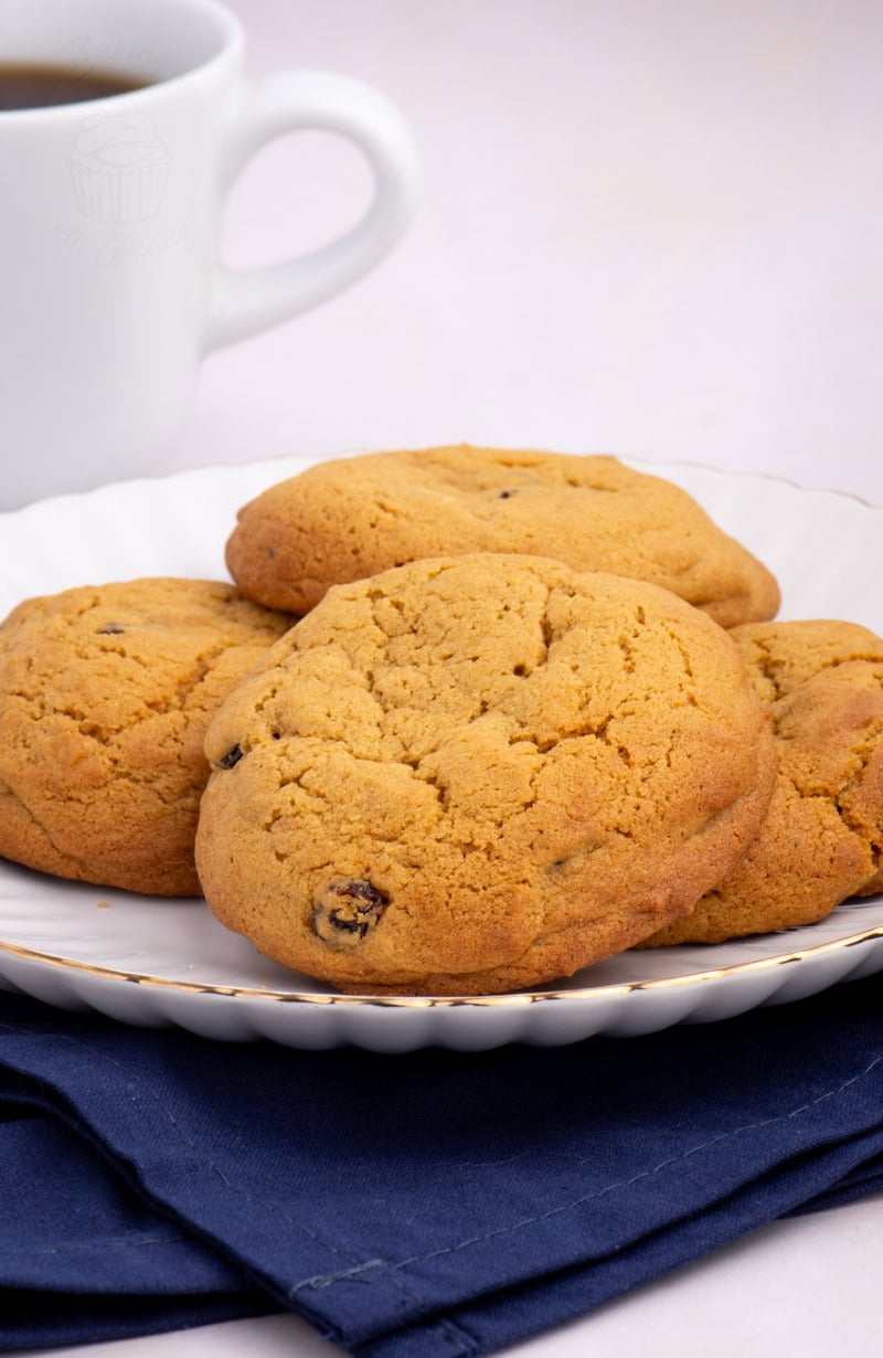 Stack of golden Coffee Buns on a plate with a cup of coffee in the background.