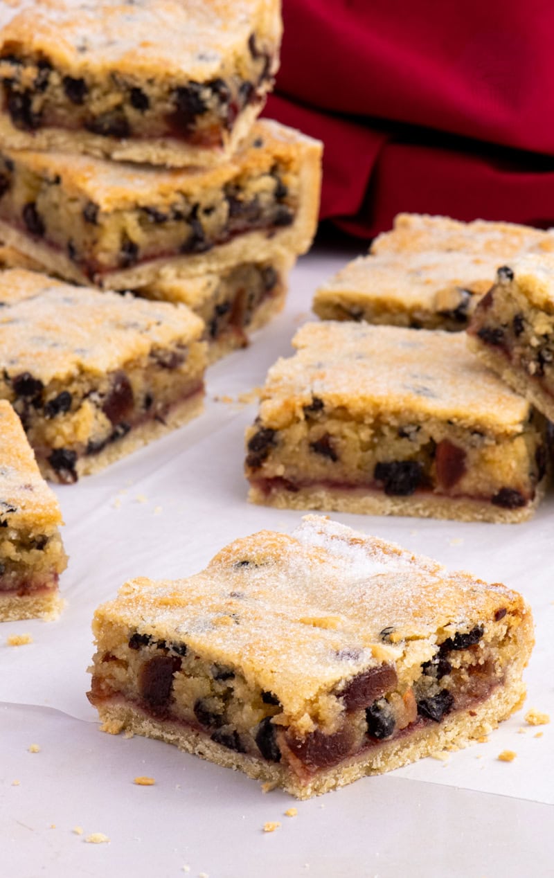 Paradise Slice squares arranged on baking paper, with fruit and jam layers visible in each piece.