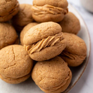 Plate of homemade coffee kisses biscuits with coffee buttercream filling.