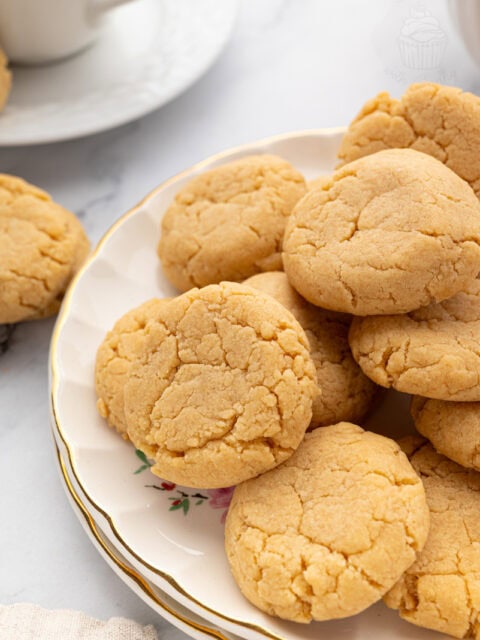 Plate of homemade gingernut biscuits stacked on a floral china plate.