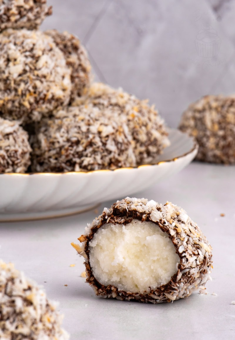 Scottish Macaroon cut in half on a plate, revealing the creamy potato fondant centre with chocolate and coconut coating.
