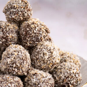 Plate stacked high with homemade Scottish Macaroons, coated in chocolate and coconut.