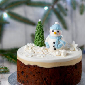 Classic Christmas Cake recipe. Rich fruit cake, topped with marzipan and fondant icing. Decorated with a fondant snowman and Christmas Tree.