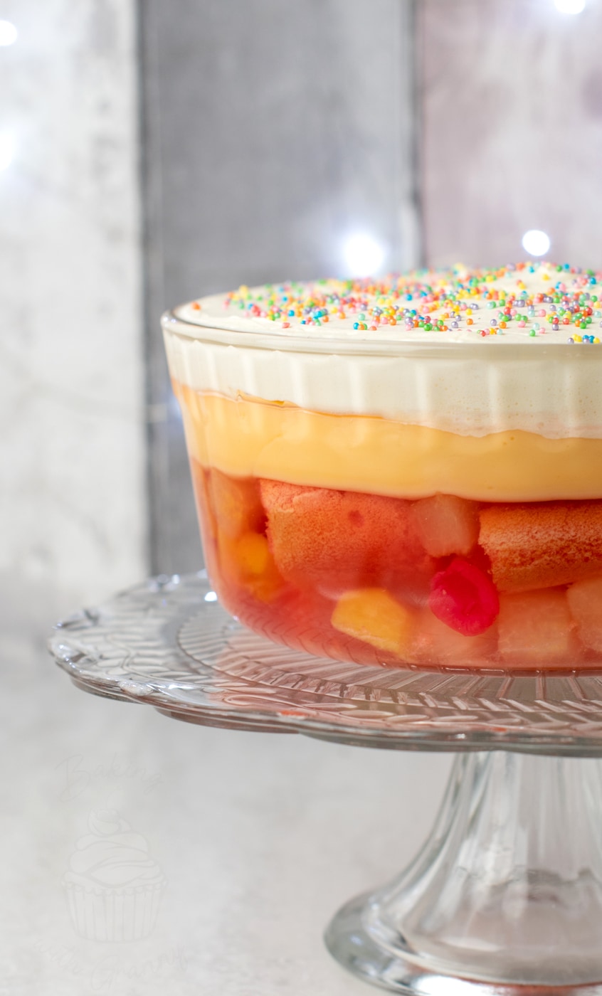 Classic British trifle layered with jelly, sponge, fruit, custard and whipped cream in a glass bowl - easy homemade trifle recipe.