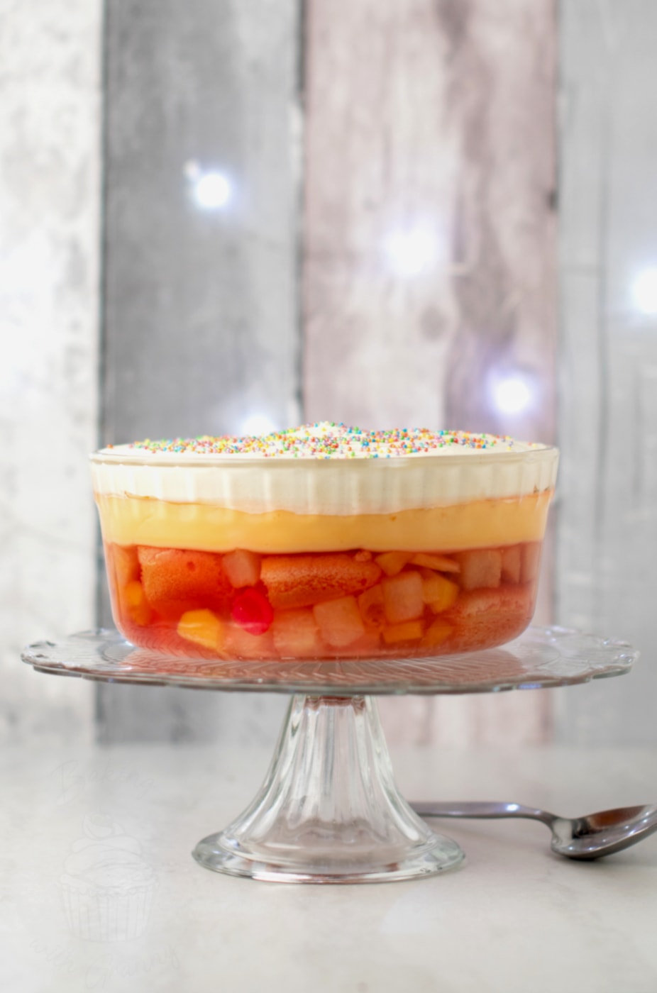 Easy trifle made to traditional Scottish recipe, featuring fruit cocktail, jelly, custard, cream and sprinkles.