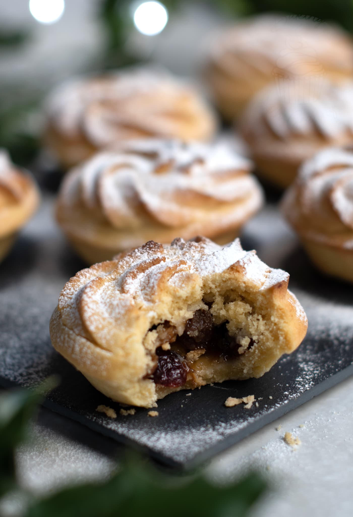Sweet mince pies, made with shortcrust pastry, juicy mincemeat, and topped with a Viennese whirl.