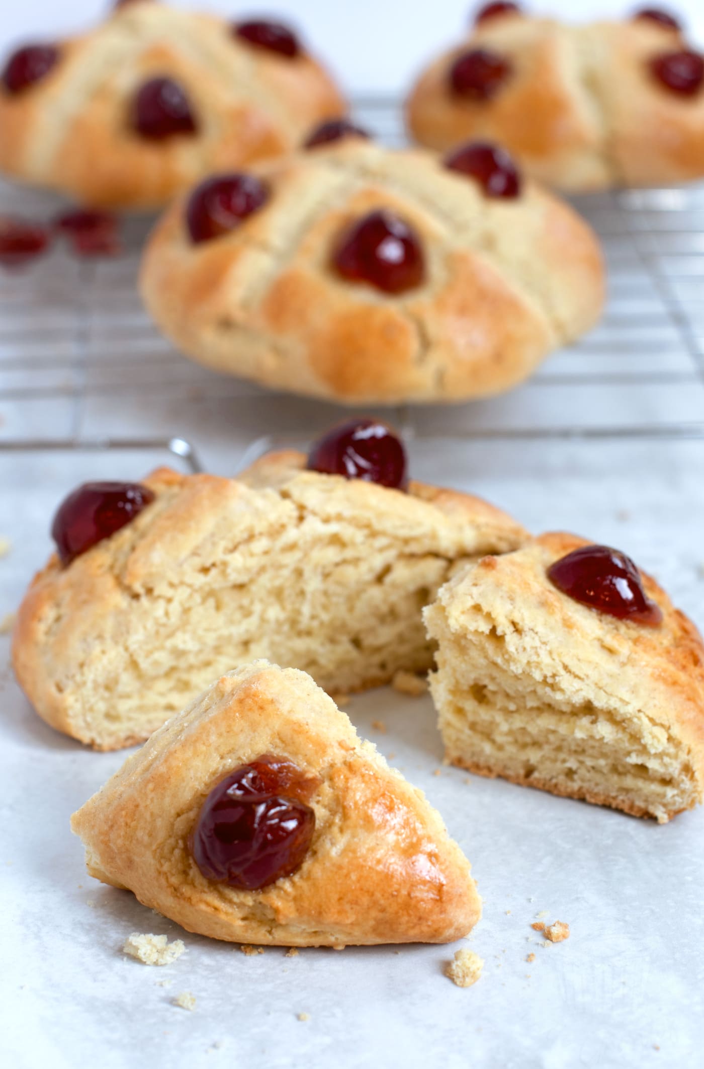 Victoria Scone cut into quarters to serve, with a few whole scones seen in the distance behind.