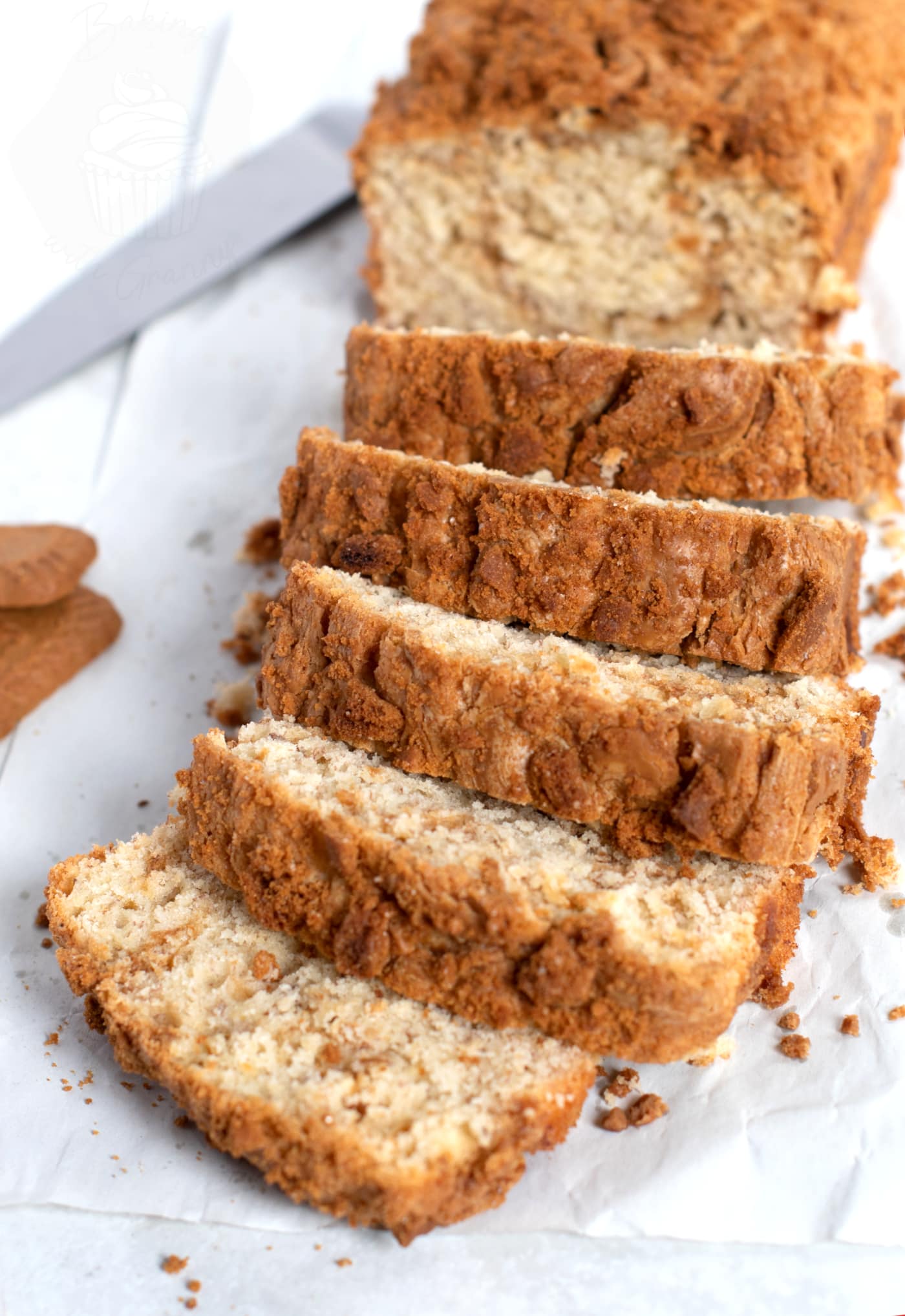 Sliced Biscoff Banana Bread. Golden on the outside, with a Biscoff biscuit crumb topping. Paler on the inside, with a Biscoff spread swirl throughout.