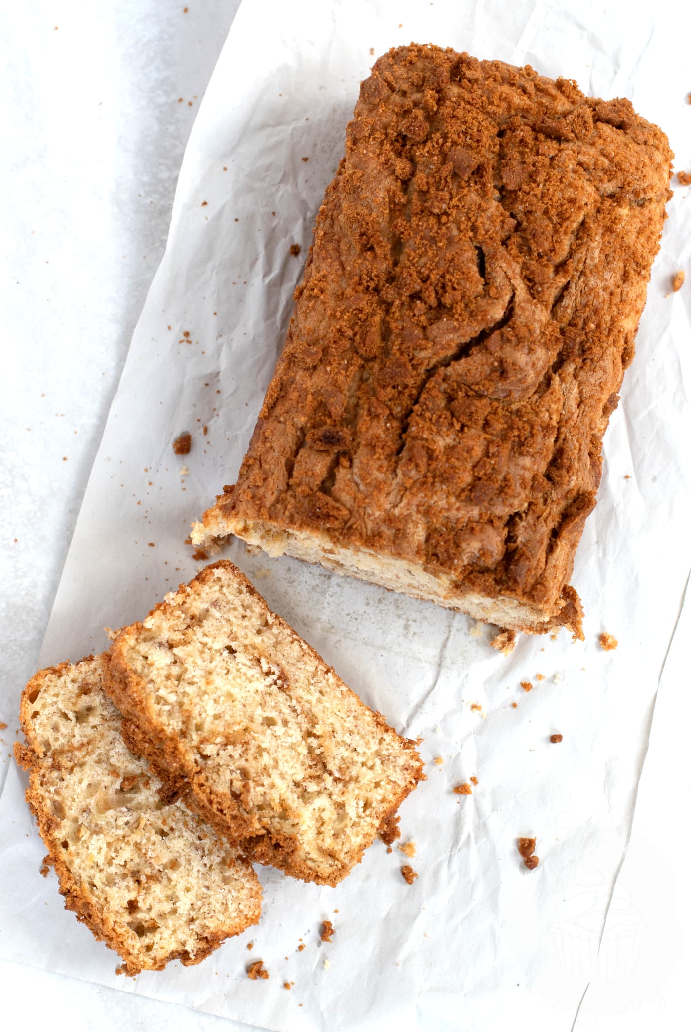 Banana Loaf with a swirl of Biscoff spread seen in the slices, and a Biscoff biscuit crumb on top.