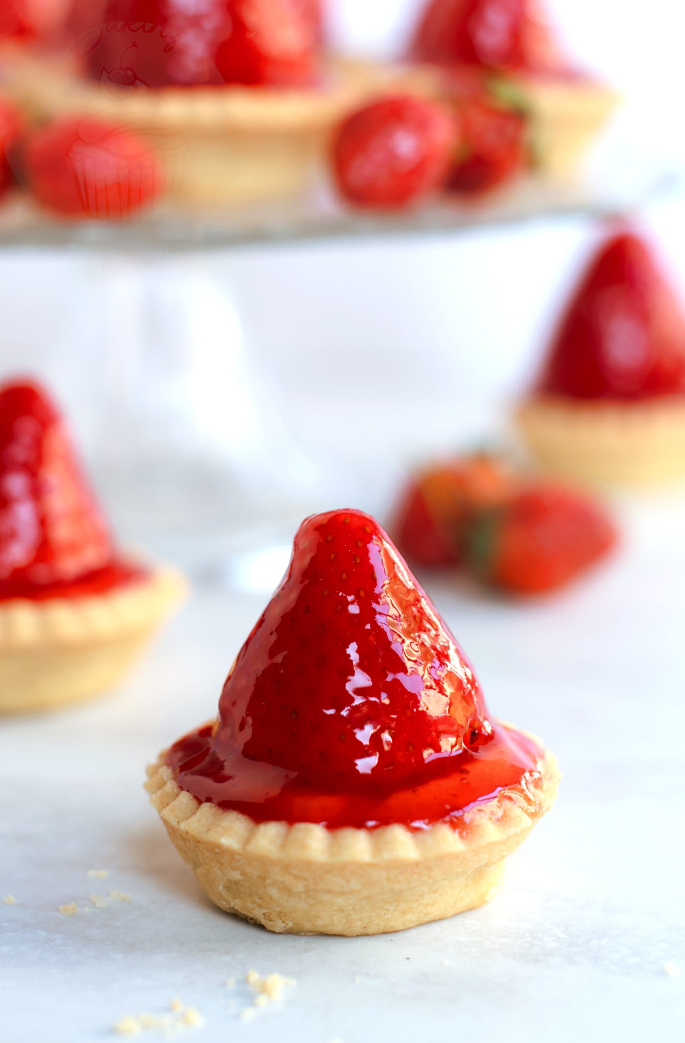 Strawberry tart made to a traditional Scottish recipe, with more tarts and extra strawberries in the background.