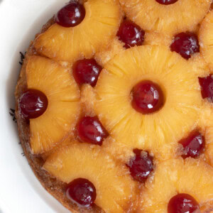 Upside-down Pineapple Cake, with golden pineapple rings, dotted with red glace cherries.