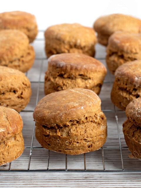 Freshly baked Scottish treacle scones cooling on a metal rack against a light background.