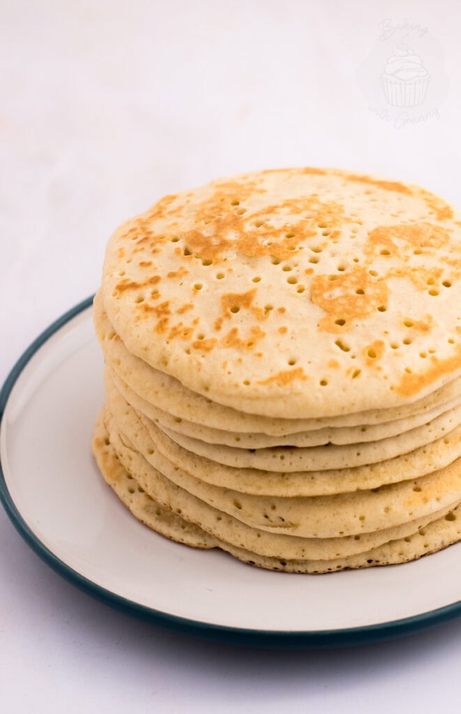 Traditional Scottish crumpets stacked on a plate, photographed against a light background.
