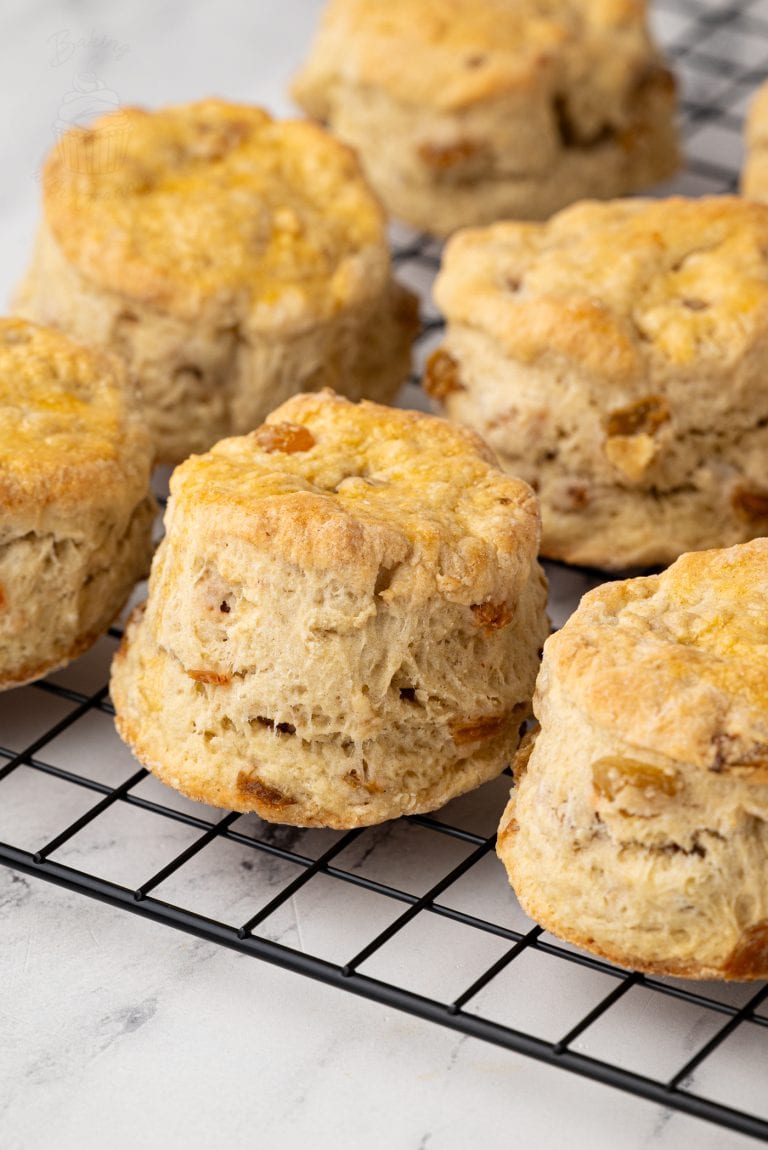 Wire rack filled with traditional Fruit Scones, with a pastry cutter in the background.