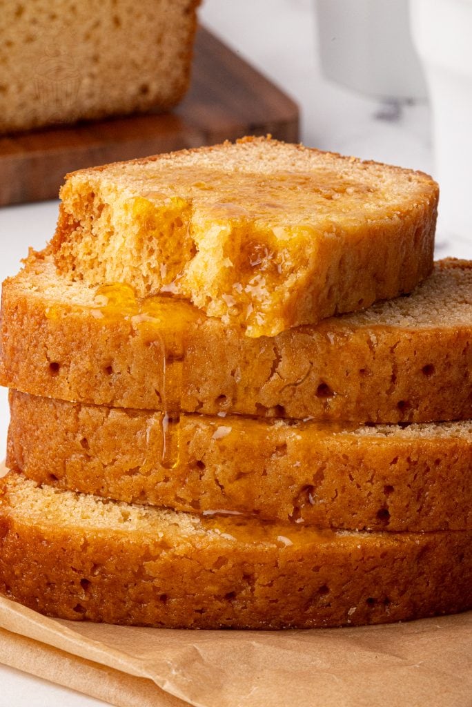 Close-up of syrup-soaked golden syrup cake with a bite taken from the top slice.