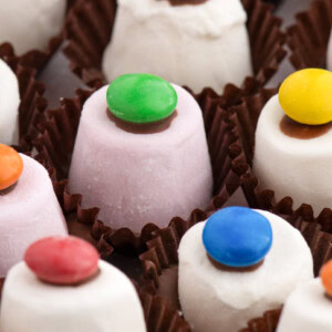 Close-up of colourful smartie-topped Marshmallow Top Hats in brown cases, traditional Scottish sweet.