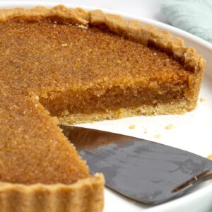 Treacle tart with a golden syrup filling inside crisp pastry.