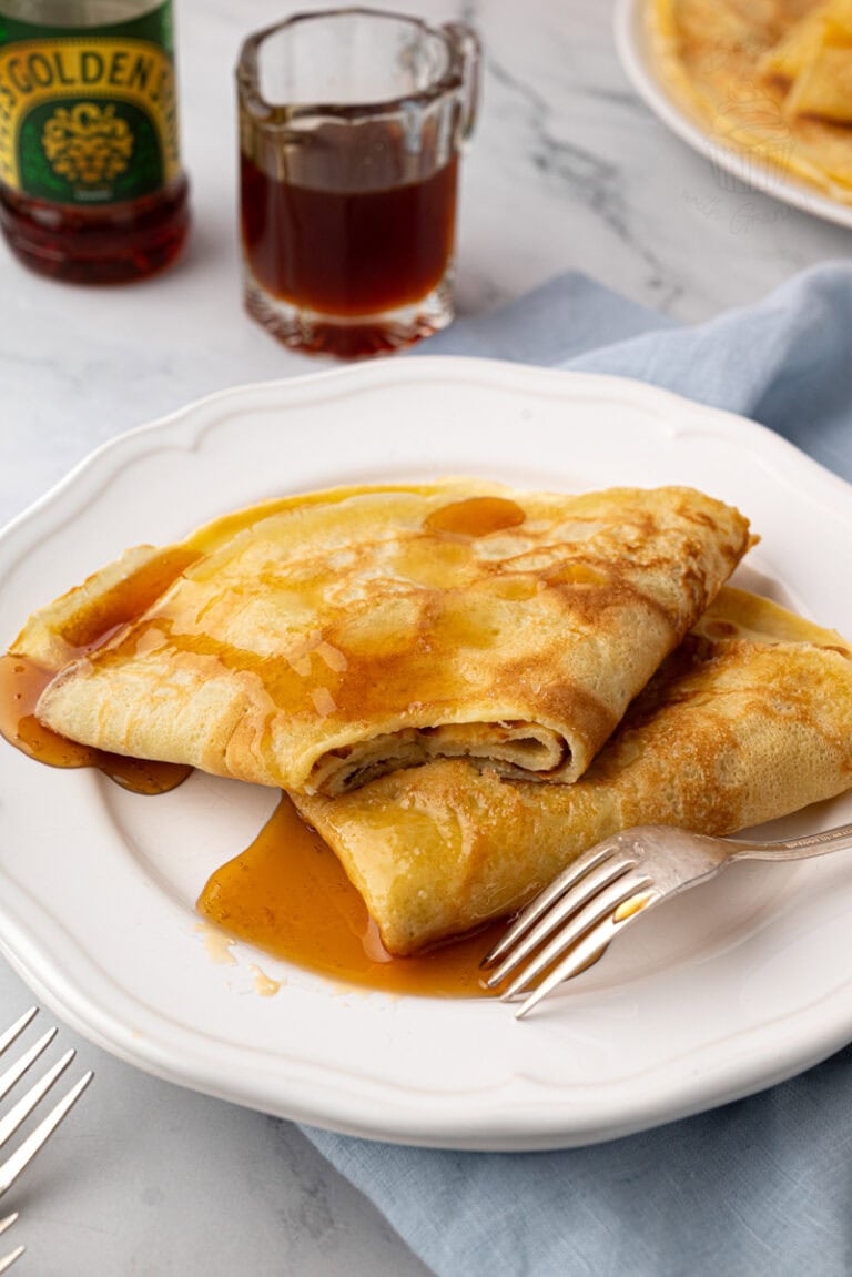 Traditional English-style pancakes folded and drizzled with golden syrup.