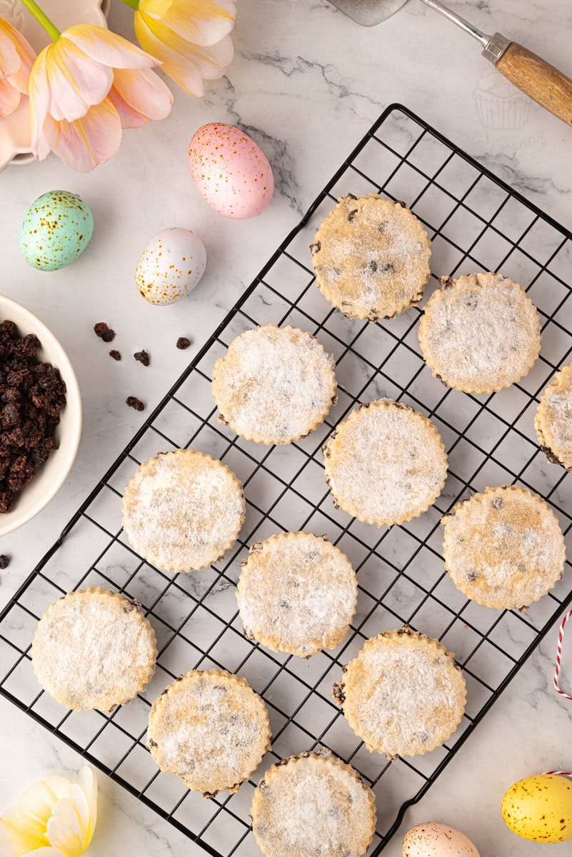 Easter biscuits cooling on a wire rack, evenly baked with a light golden colour and sugar-dusted tops.
