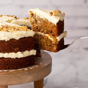 Slices of carrot cake with creamy frosting and visible walnut pieces.