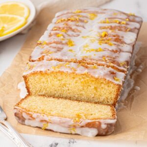 Sliced lemon drizzle loaf cake with a crisp sugary topping.