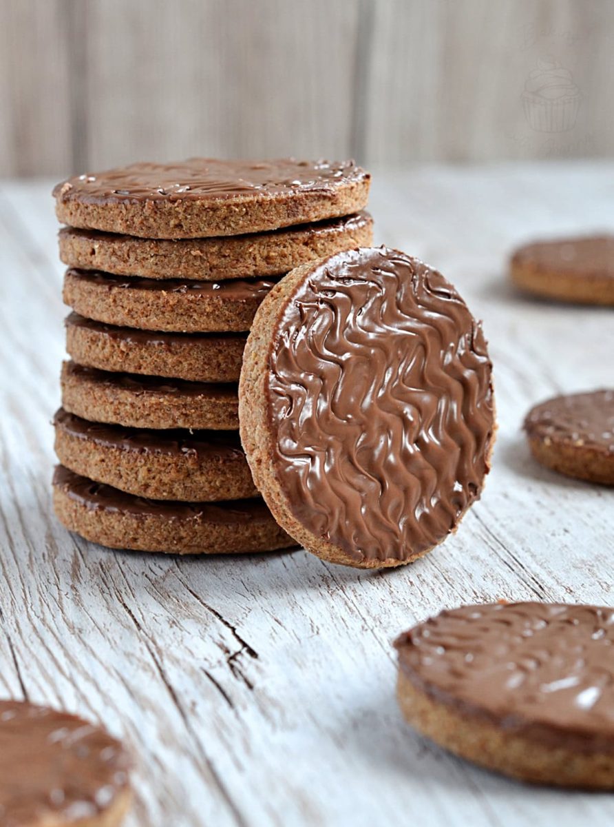 Chocolate Digestive A tall stack of British chocolate digestive biscuits, with one cookie resting in front to display the rich chocolate coating and crumbly edge.