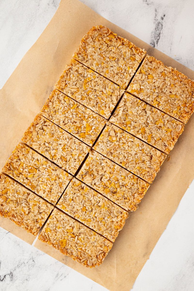 Overhead view of a full tray of honey slice cut into even bars on brown parchment paper.