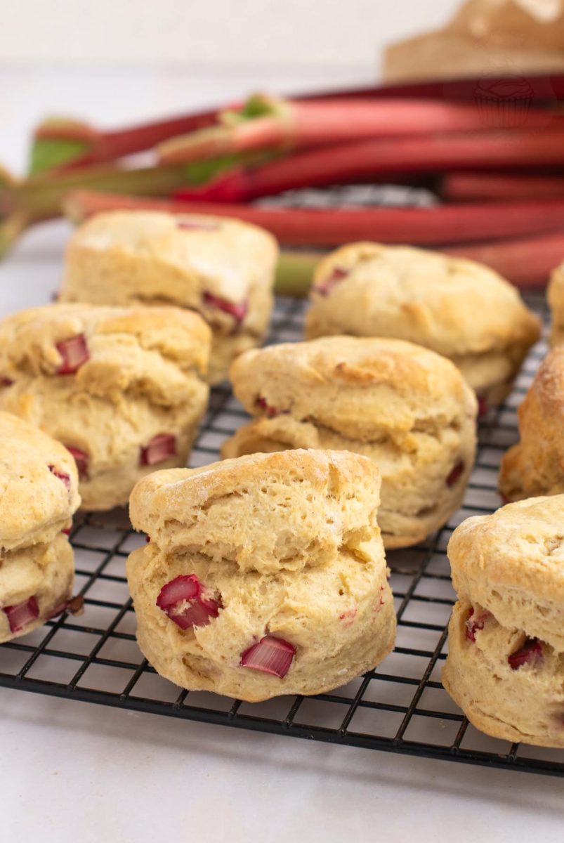Rhubarb Scones Freshly baked Rhubarb Scones cooling on a wire rack, with freshly chopped rhubarb visible in the dough.